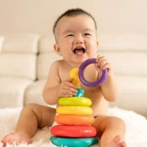 baby playing with a stacking ring toy