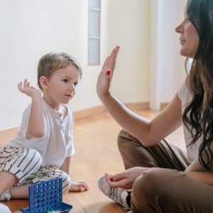 mother giving high five to son while playing a game