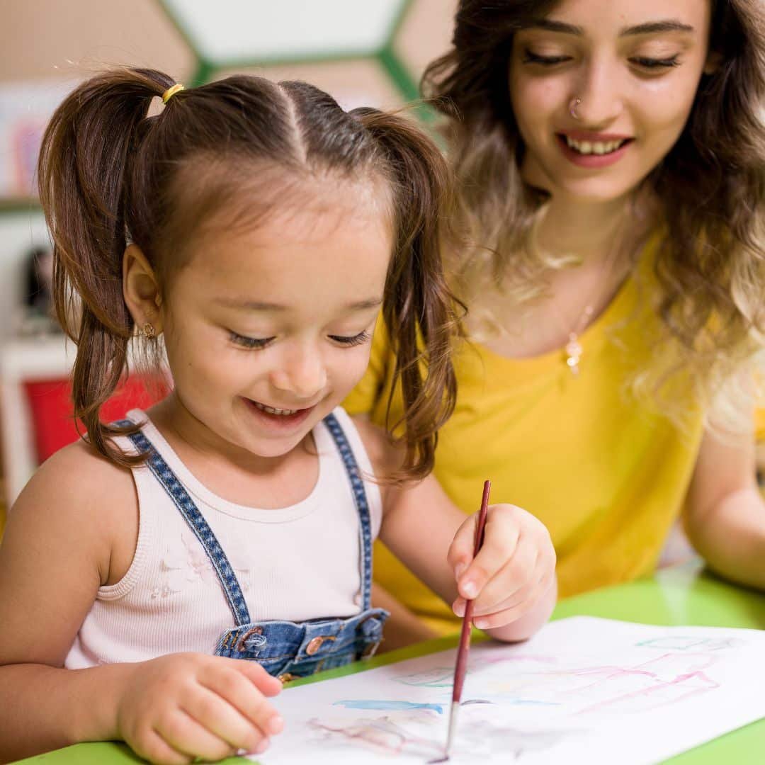 Teacher helping child with art